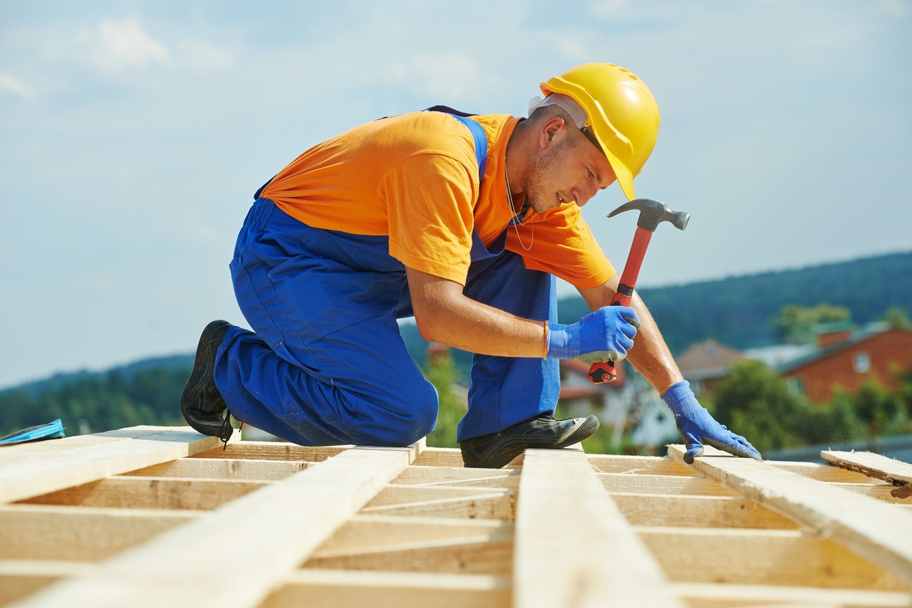 Construction-couvreur-ouvrier-charpentier-clouer-planche-de-bois-avec-un-marteau-sur-les-travaux-dinstallation-sur-le-toit